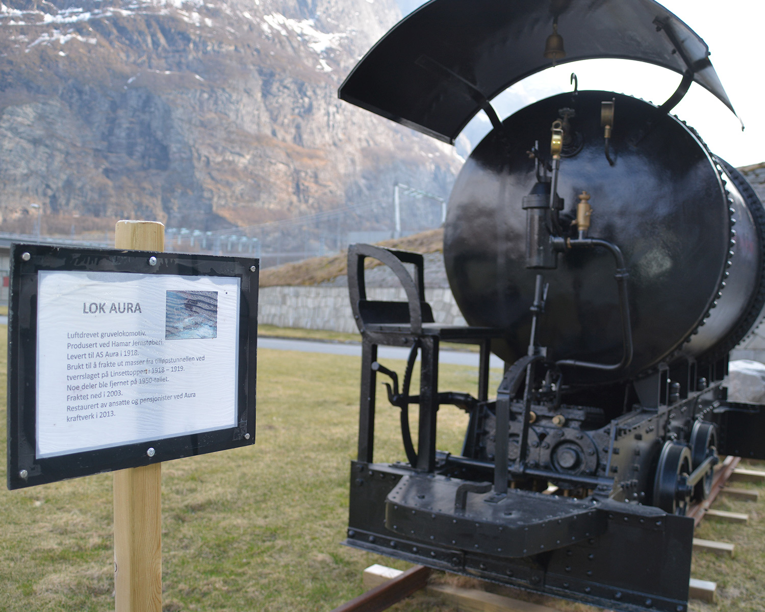 A train engine from the construction period has been restored and placed outside the power plant